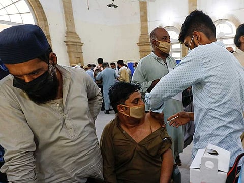 A man receives a dose of vaccine in Karachi. For the first time active cases have been reported less than 70,000 since July 31 this year.