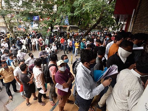 In this April 8, 2021 file photo, people wait in queues outside the office of the Chemists Association to demand necessary supply of the anti-viral drug Remdesivir, in Pune, India. As India faces a devastating surge of new coronavirus infections overwhelming the health care system, people are turning to desperate measures to keep loved ones alive.