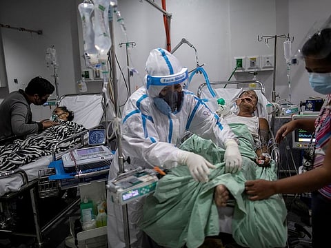 A health worker tends to a coronavirus disease (COVID-19) patient supported by a mechanical ventilator and undergoing dialysis at the COVID-19 emergency room of the government hospital National Kidney and Transplant Institute in Quezon City, which has declared overcapacity amid rising numbers of COVID-19 infections in Quezon City, Metro Manila, Philippines, April 26, 2021.