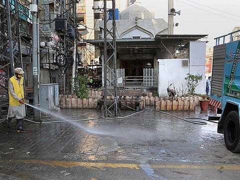 A municipality worker sprays disinfectant outside a mosque in an effort to contain the outbreak of the coronavirus, in Peshawar, Pakistan, Thursday, April 29, 2021. 