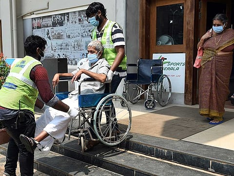 Health workers help an elderly woman as she leaves after receiving the COVID-19 vaccine, in Thiruvananthapuram on Tuesday, April 27, 2021. 