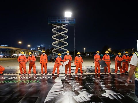 The workers were transported to a site where they unknowingly pieced together a massive tile structure with a hidden message. 