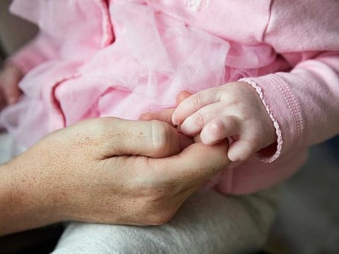 A mother holds the hand of her infant daughter in East Amherst, New York, on Dec. 5, 2020. The birthrate in the United States has fallen by about 15 per cent since its recent peak in 2007. 