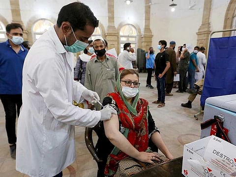 A woman receives the first shot of the Sinopharm COVID-19 vaccine from a health worker at a vaccination centre in Karachi, Pakistan, Wednesday, May 5, 2021. 