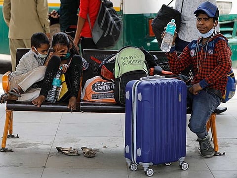 Children of migrant workers wait for transportation at a bus station during a lockdown in New Delhi, India, Friday, April 30, 2021. 