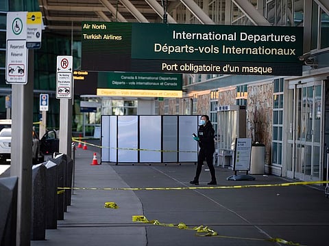 A Royal Canadian Mounted Police officer works at the scene after a shooting outside the international departures terminal at Vancouver International Airport, in Richmond, British Columbia, Sunday, May 9, 2021.