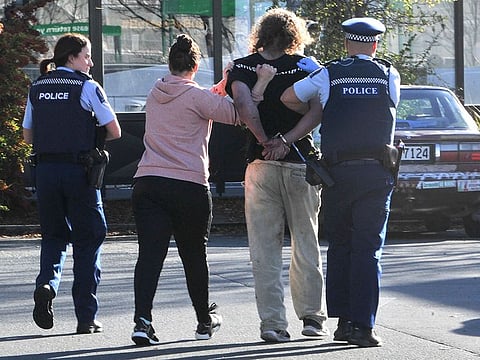 Police take a suspect into custody near the Countdown supermarket in central Dunedin, New Zealand, Monday, May 10, 2021. 