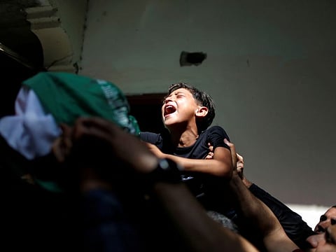 The brother of Palestinian man Ahmed Al Shenbari, who was killed amid a flare-up of Israeli-Palestinian violence, reacts as mourners carry his body during his funeral in the northern Gaza Strip May 11, 2021. 