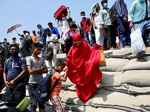People rush with their belongings to board a ferry at Mawa Ferry Terminal to get home to celebrate Eid al-Fitr, after the government imposed coronavirus disease (COVID-19) restrictions on long-route public transport, in Munshiganj, Bangladesh, May 12, 2021. 