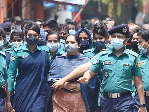 Police escort investigative journalist Rozina Islam (C) to a court in Dhaka on May 18, 2021. 