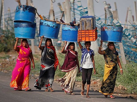 Women carry their belongings after salvaging them from their damaged workplaces at a fishing harbour following Cyclone Tauktae in Jafrabad in the western state of Gujarat, India, May 19, 2021. 