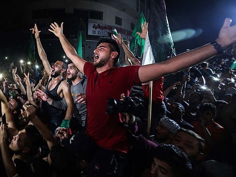 People take to the streets to celebrate following a ceasefire brokered by Egypt between Israel and the ruling Islamist movement Hamas in the Gaza Strip, in Gaza City early on May 21, 2021. 