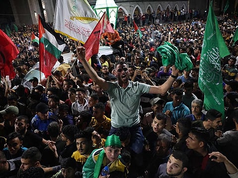 People celebrate in the streets following a ceasefire brokered by Egypt between Israel and the ruling Islamist movement Hamas, in Rafah, in the southern Gaza Strip on May 21, 2021.
