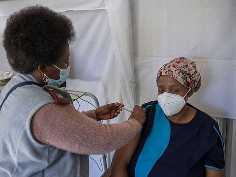 A health care worker administers a jab containing Pfizer vaccine on a caregiver of the SAVF Evanna Tehuis old age home near Klerksdorp, on May 19, 2021. South Africa is resuming its COVID-19 coronavirus Phase 2 vaccination rollout programme which targets vulnerable groups who are 60 years and older.
