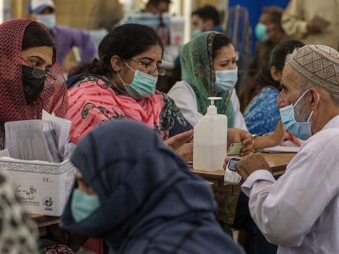 Health workers register people to receive a dose of the AstraZeneca Plc COVID-19 vaccine at a vaccination centre set up in Karachi, Pakistan, on Tuesday, May 11, 2021. 