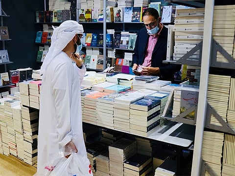 People enjoy browsing through books on display on the first day of the Abu Dhabi International Book Fair on Sunday.