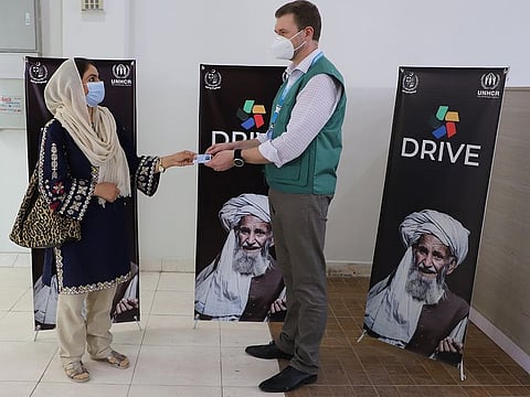 An Afghan refugee receives her smartcard from a NADRA official at the Documentation Renewal and Information Verification Exercise Centre Islamabad.