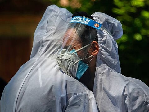 A relative comforts wailing son of a person who died of COVID-19, at a crematorium in Srinagar, India. India's death toll is the third-highest reported in the world after the U.S. and Brazil.
