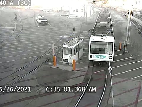 A man (top L), identified by police as Samuel Cassidy, a transit employee who gunned down nine co-workers and killed himself, is seen walking across a rail depot in San Jose, California, U.S., May 26, 2021, in this still image taken from CCTV footage.
