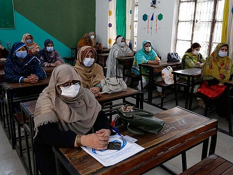 Teachers await their turn to receive the first shot of the Sinovac coronavirus vaccine at a school in Lahore, Pakistan, Friday, May 28, 2021. 