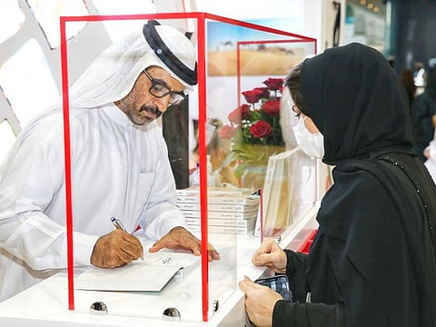 HHC CEO Abdullah Hamdan Bin Dalmook during the book signing ceremony at ADIBF.