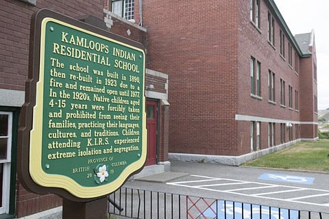A plaque is seen outside of the former Kamloops Indian Residential School on Tk’emlups te Secwépemc First Nation in Kamloops, British Columbia on Thursday, May 27, 2021. The remains of 215 children have been found buried on the site of a former residential school in Kamloops, B.C. THE CANADIAN PRESS/Andrew Snucins