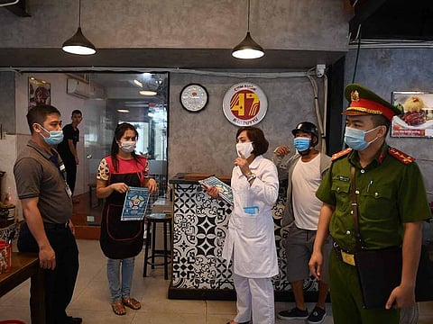 Health and local officials inspect a restaurant in Hanoi as city authorities expanded closure orders to include restaurants dine services, barbershops and hair salons to prevent the spread of COVID-19. 