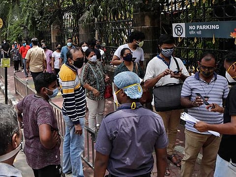 People line up to receive vaccine for COVID-19 outside a vaccination centre in Mumbai, India, Saturday, May 29, 2020. 