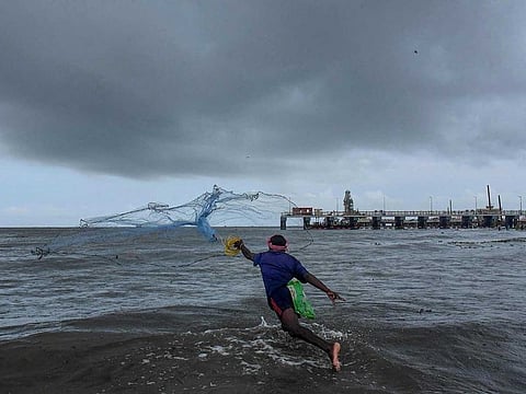 A fisherman casts his net at a seaside in Kochi, Saturday, May 29, 2021. Monsoon rains are expected to hit Kerala on June 3, 2021.  