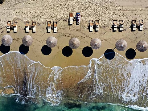 A woman enjoys the sun at Plaka beach on the Aegean island of Naxos, Greece. 