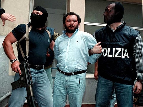 Anti-Mafia police wearing masks to hide their identity, escort top Mafia fugitive Giovani Brusca May 21 as he leaves Palermo's police headquarters to be taken to a maximum security prison. Brusca, accused of mastermining the highway bombing that killed anti-mob judge Giovanni Falcone along with his wife and three bodyguards on May 23, 1992, and is also believed to have succeeded Salvatore "Toto" Rina as the Mafia's boss of bosses, was arrested with his brother Vincenzo.