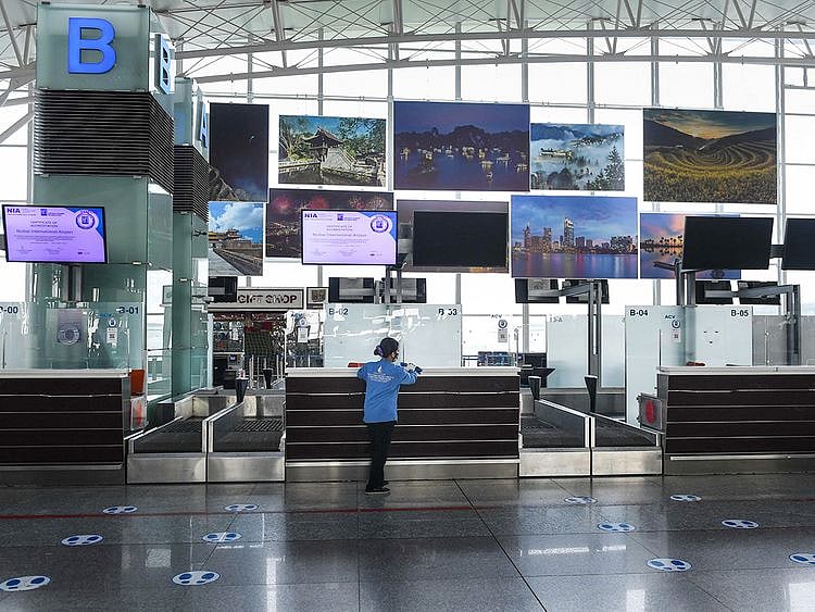 A cleaner cleans a check-in counter area of Noi Bai International Airport in Hanoi. 