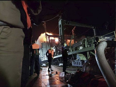 This photo made available by Asriran.com on Wednesday, June 2, 2021 shows personnel standing on Iran’s navy support ship Kharg after being caught on fire in the Gulf of Oman.  