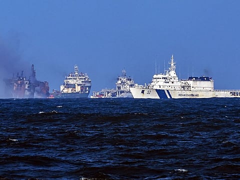 A tugboat (2L) from the Dutch salvage firm SMIT tows the fire stricken Singapore-registered container ship MV X-Press Pearl (L) away from the coast of Colombo on June 2, 2021 following Sri Lankan President Gotabaya Rajapaksa's order to move the ship to deeper wate