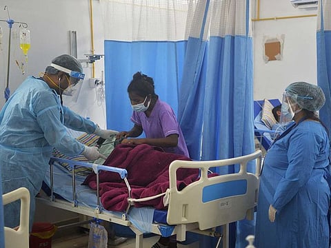 In this picture taken on June 1, 2021 a doctor (C) checks on a COVID-19 coronavirus patient at an Intensive Care Unit (ICU) of the Nightingale Hospital, on the outskirts of Siliguri. 