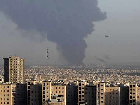 Huge smoke rises up from Tehran's main oil refinery as a plane approaches Mehrabad airport south of Tehran, Iran, Wednesday. 