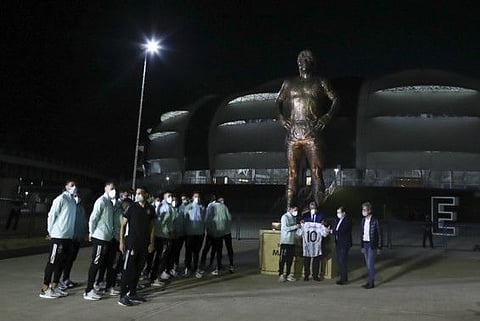 Argentina's Lionel Messi, center left, Argentine Football Association (AFA) President Claudio Tapia, center, and Santiago del Estero province Governor Gerardo Zamora hold a jersey with Maradona's number at the unveiling of a Maradona statue outside Madre de Ciudades stadium prior to a qualifying soccer match for the FIFA World Cup Qatar 2022 between Argentina and Chile in Santiago del Estero, Argentina.