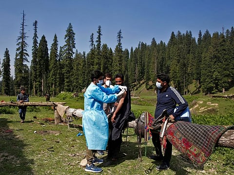 A healthcare worker gives a dose of Covishield vaccine manufactured by Serum Institute of India to a shepherd man during a vaccination drive at a forest area in south Kashmir's Pulwama district.