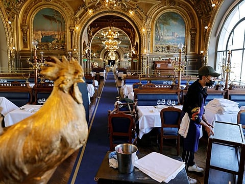An employee works in a dining room inside Le Train Bleu restaurant, an iconic restaurant in the Gare de Lyon station in Paris as cafes, bars and restaurants prepare to reopen indoor dining rooms with a fitted gauge and health protocol after closing down for months in France, on Wednesday.