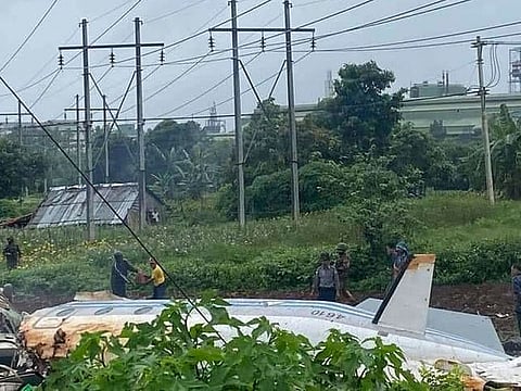 In this handout photo provided by the Myanmar Ministry of Information, military and locals stand beside the wreckage of a Myanmar Air Force Beechcraft 1900 that crashed in Pyin Oo Lwin, Mandalay, Myanmar on Thursday June 10, 2021. 