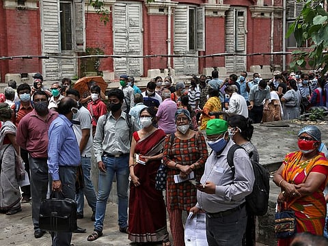 People wearing protective face masks wait to receive their second dose of COVISHIELD, a coronavirus disease (COVID-19) vaccine manufactured by Serum Institute of India, outside a vaccination centre in Kolkata, India, May 12, 2021.