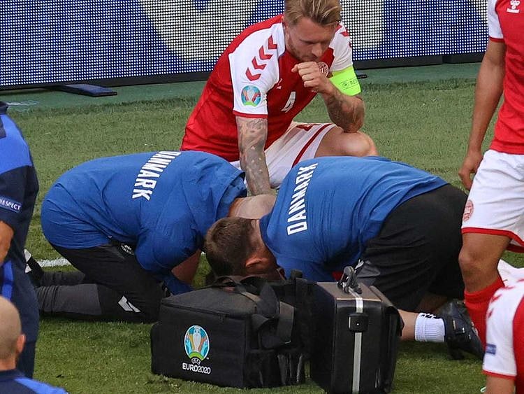  Denmark's defender Simon Kjaer (back) observes as paramedics attend to Denmark's midfielder Christian Eriksen (not seen) during the UEFA EURO 2020 Group B football match between Denmark and Finland at the Parken Stadium in Copenhagen on June 12, 2021. 