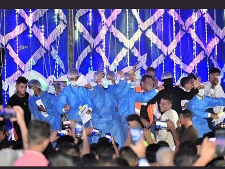 Guests wearing medical attire look happy at the wedding
