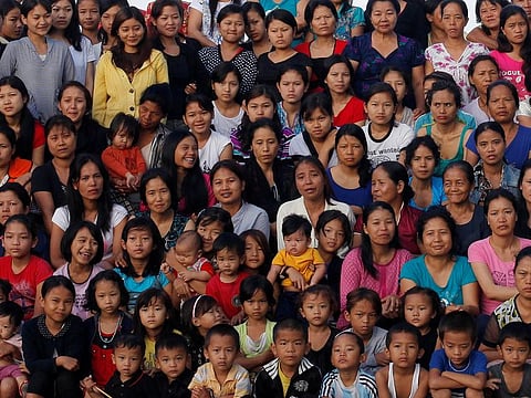 Family members of Ziona pose for a group photograph in Baktawng village in the northeastern Indian state of Mizoram, October 7, 2011. Ziona is the head of a religious sect called "Chana," which allows polygamy and was founded by his father Chana in 1942. Ziona has 39 wives, 94 children and 33 grandchildren. He lives in his 4 storey 100-room house with 181 members of his family. The world's population will reach seven billion on 31 October 2011, according to projections by the United Nations.   