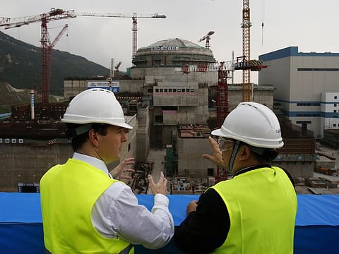  In this file photo taken October  17, 2013, then British Chancellor of the Exchequer George Osborne, left, chats with Taishan Nuclear Power Joint Venture Co. Ltd. General Manager Guo Liming as he inspects a nuclear reactor under construction at the nuclear power plant in Taishan, southeastern China's Guangdong province.  