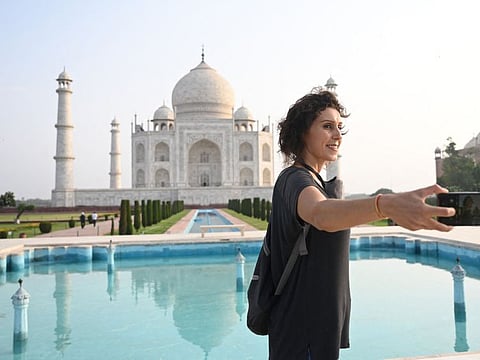 Melissa Dalla Rosa from Brazil takes souvenir photos at the Taj Mahal after it reopened to visitors.