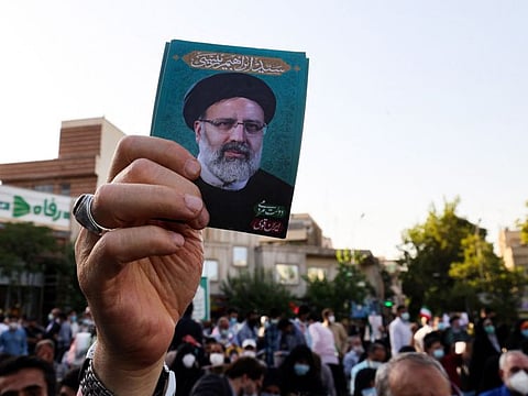 A supporter of Iranian ultraconservative presidential candidate Ebrahim Raisi raises his portrait during a rally in the capital Tehran, on June 16, ahead of the June 18 presidential election. 