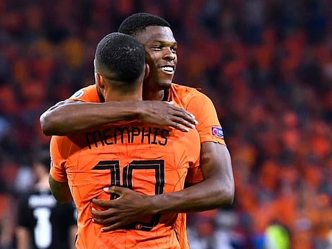 Netherlands' Denzel Dumfries celebrates scoring their second goal with teammate Memphis Depay.