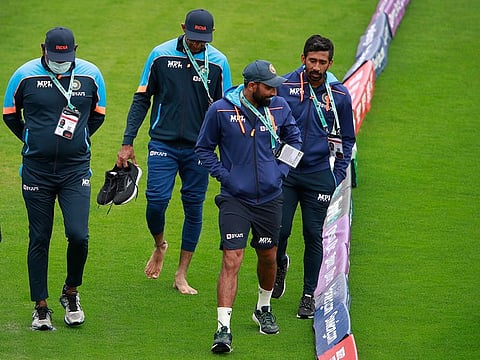 Members of Indian cricket team, Mohammed Shami and Wriddhiman Saha, take a stroll along with support staff around the Ageas Bowl on a rain-swept day.