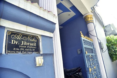 A nameplate stands at the entrance of the house of Dr. Jibraeil, assistant professor of history at Aligarh Muslim University, who died of COVID-19, in Aligarh,  on June 12, 2021. Within just one month, the official Facebook page of Aligarh Muslim University, one of the topmost in India, published about two dozen obituaries of its teachers, all lost to the pandemic. 